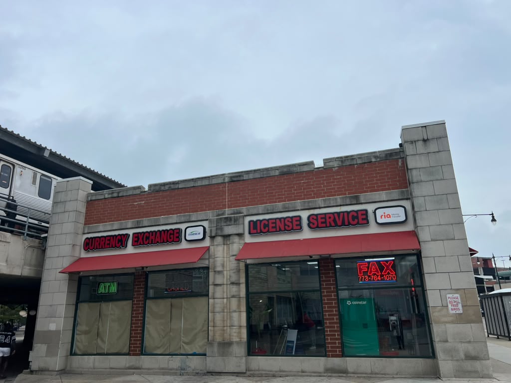 Full exterior of New Howard Currency Exchange with Currency Exchange and License Service signs next to the CTA tracks